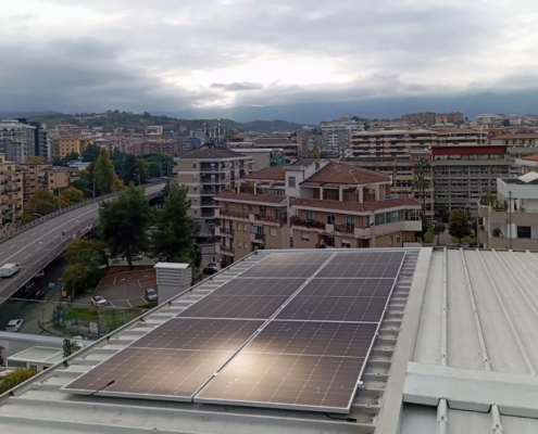 Dettaglio dell'impianto fotovoltaico da 8 kW per appartamento con lo sfondo del panorama urbano e delle colline di Cosenza città